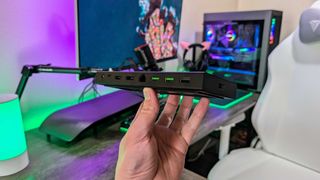 The Razer USB4 Dock held in the hand and showing its rear ports.